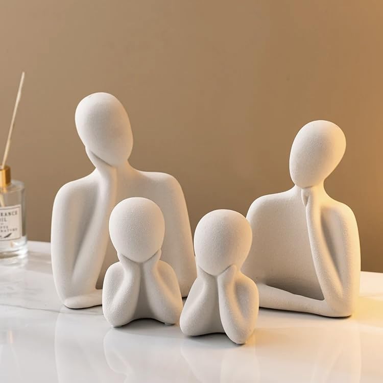 Set of four white ceramic figures on a reflective surface with a neutral background