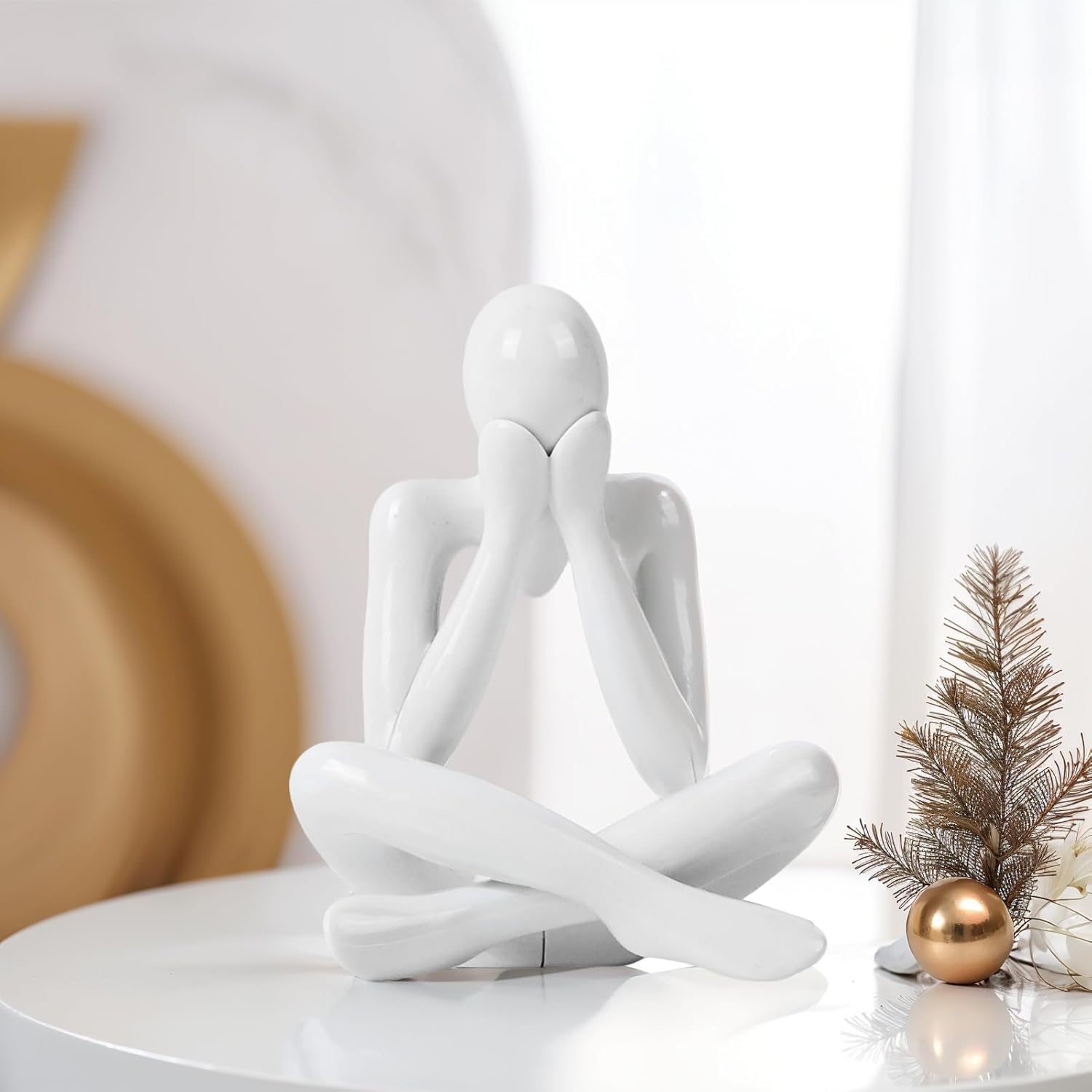 White abstract sculpture on a white surface with decorative elements in the background